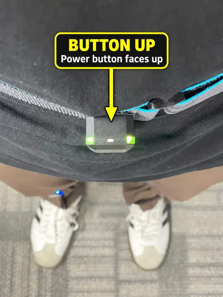 Annotated real v2 shell and new strap worn on the body; the power button is facing up.