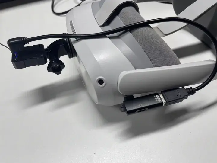 Current headset camera mounted on the headset with the camera cable plugged into the headset-connected USB adapter.